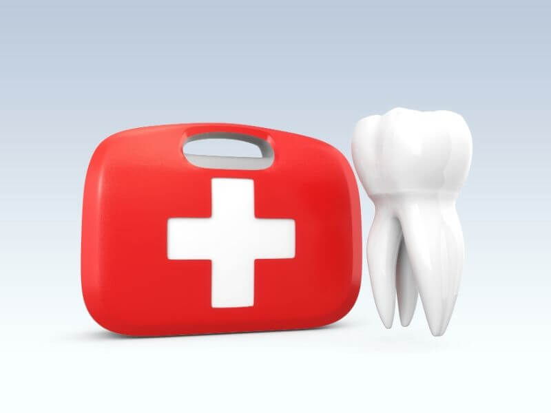 A tooth beside a first aid kit.