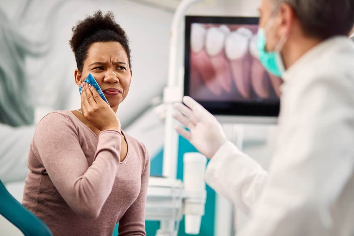 woman telling dentist tooth hurts a lot