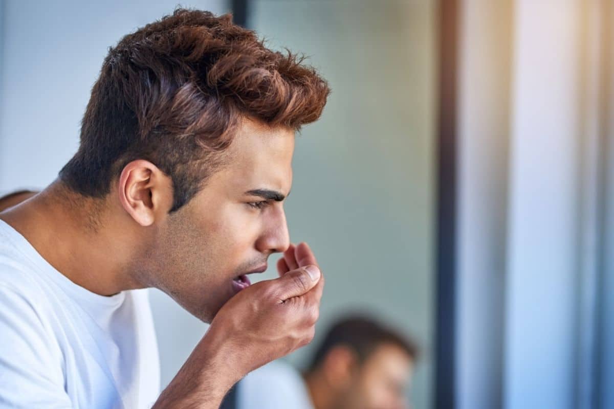 man checking on symptoms of bad breath